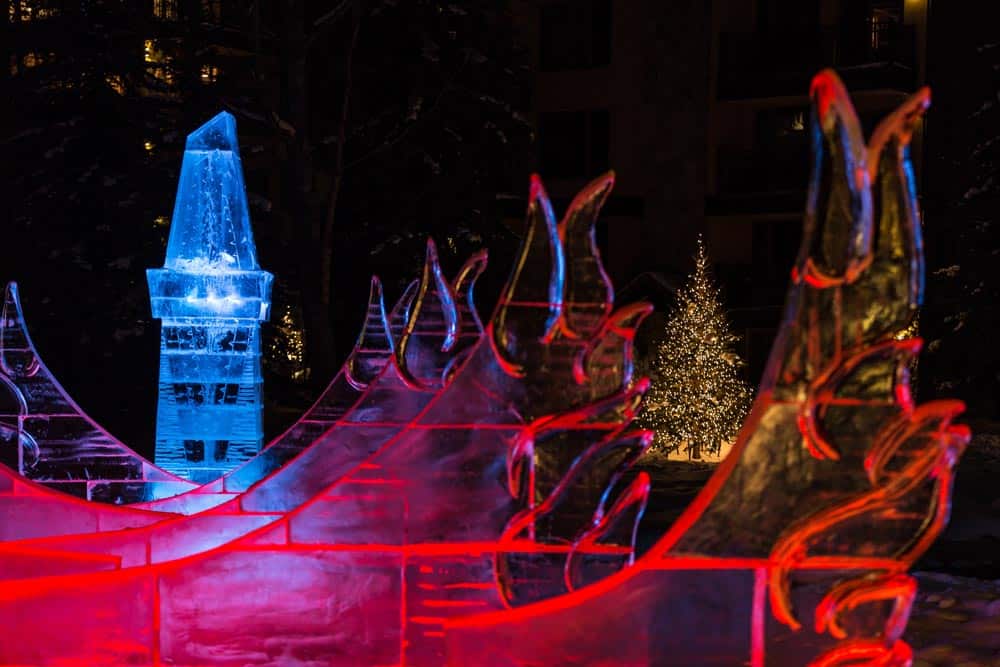 A large ice sculpture is lit up at night.