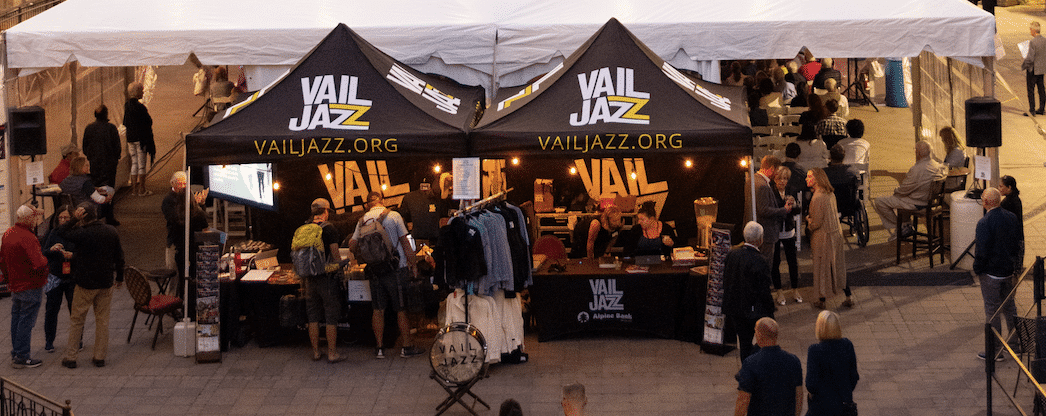 A group of people standing in front of a tent.