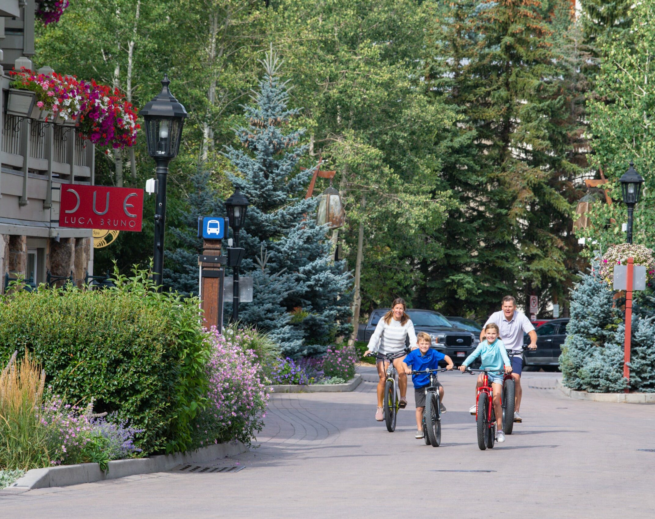 A group of people riding bikes through the beautiful streets of Vail.