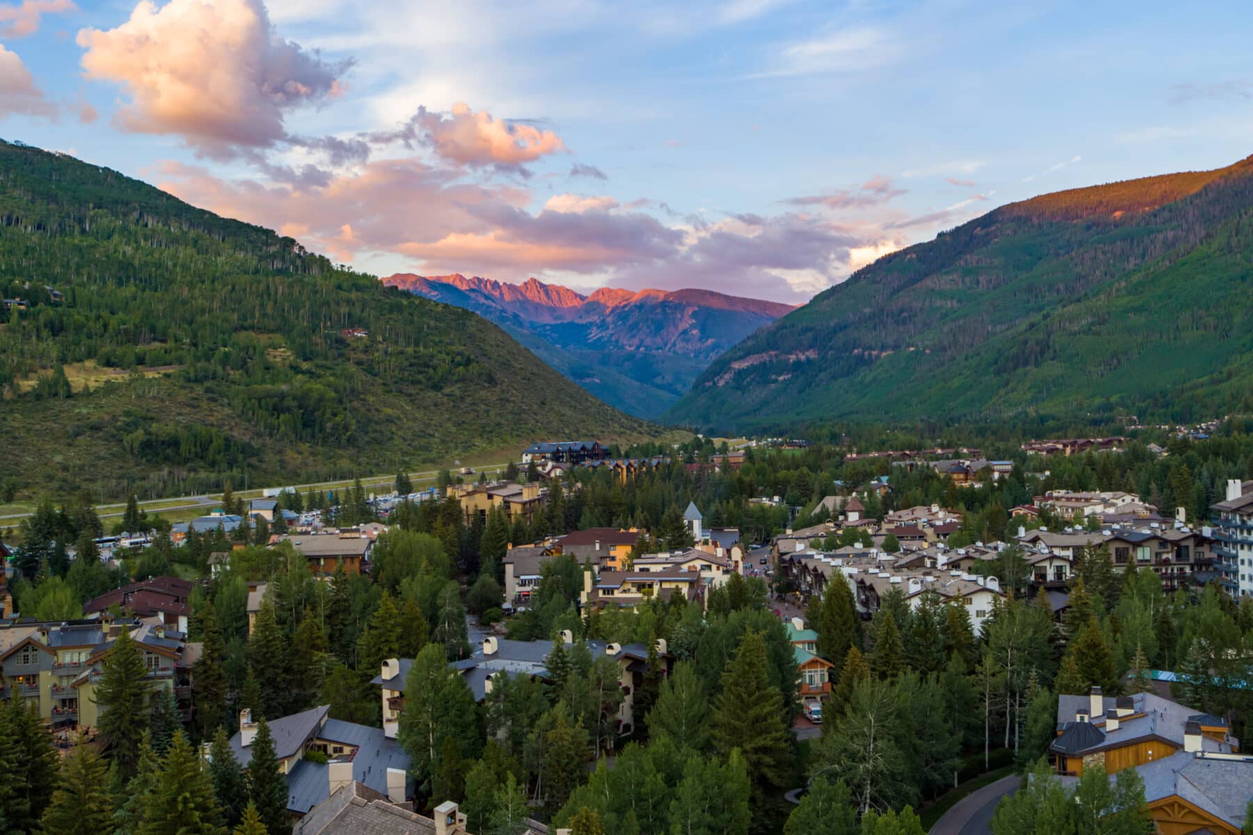 View of Vail from above at sunset with mountains in the background