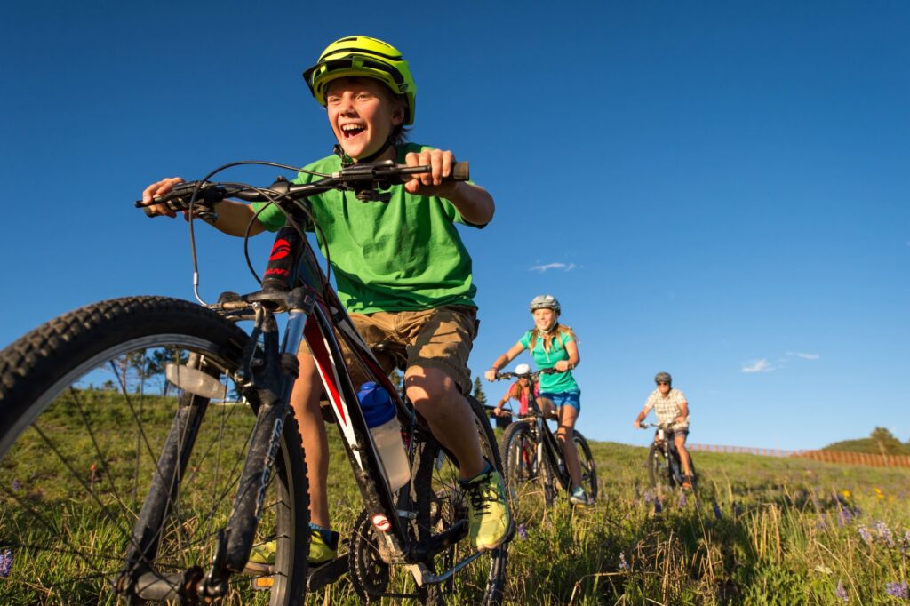 A family mountain bikes along a singletrack trail in Vail, Colorado.