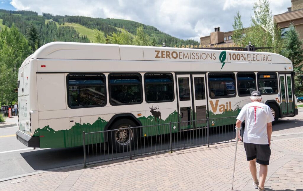 A person with a cane walks toward the bus in Vail, Colorado