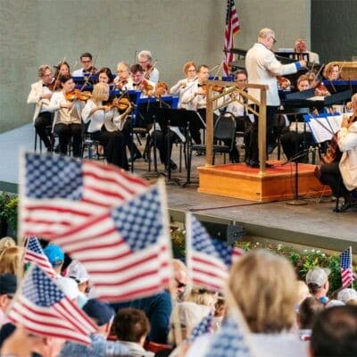 American flags waving with orchestra in the background