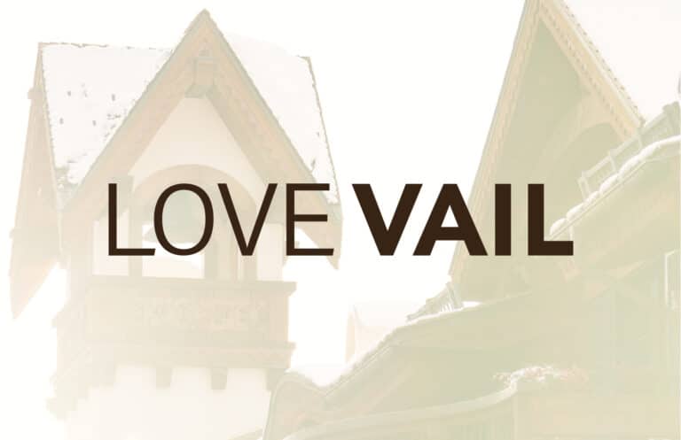 The Love Vail wordmark logo overlayed on top of an image of a building tower in the heart of Vail.