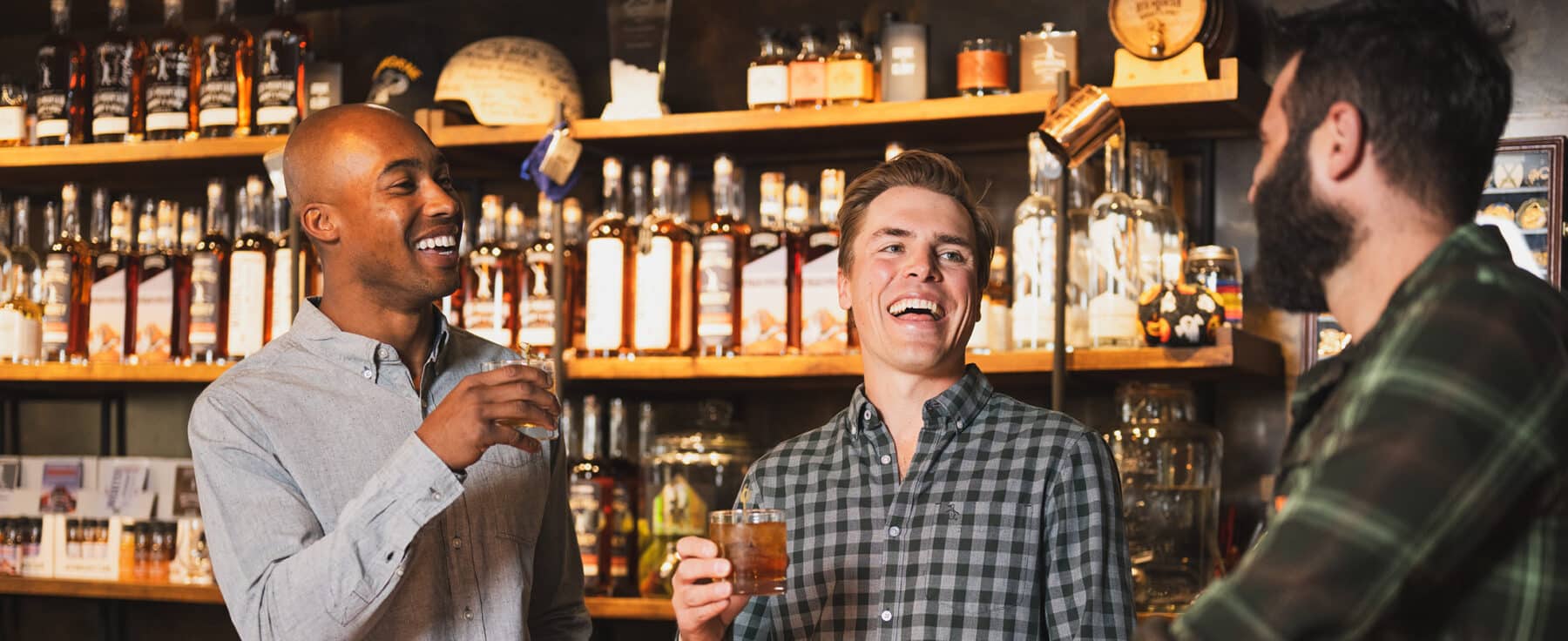 Three men stand at a bar at the 10th Mountain Whiskey & Spirits in Vail, Colorado.